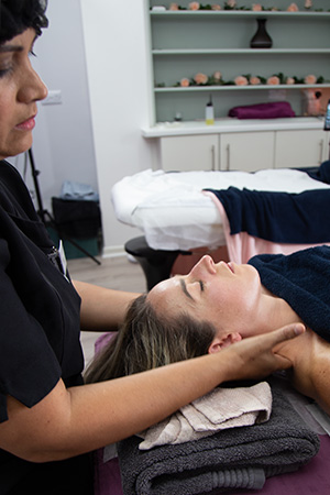 A therapist performing a focused lymphatic drainage massage on a client's neck area, promoting relaxation and wellness