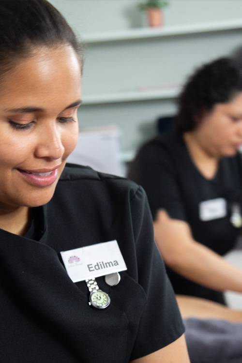 A massage therapist at Edilma Therapy, smiling and focused on her work, represents a fulfilling career in the massage industry.